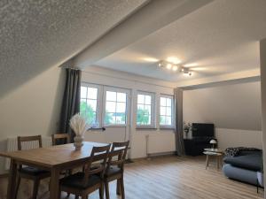 a living room with a table and a couch at Ferienwohnung Reichenbach in Bad Schussenried +5 photos