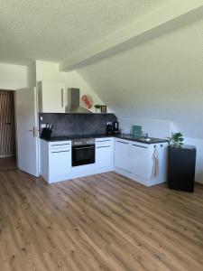 a kitchen with white cabinets and a black counter top at Ferienwohnung Reichenbach in Bad Schussenried