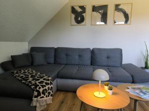 a living room with a blue couch and a table at Ferienwohnung Reichenbach in Bad Schussenried