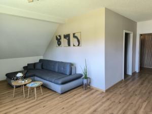 a living room with a blue couch and a table at Ferienwohnung Reichenbach in Bad Schussenried