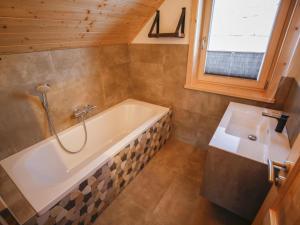 a bathroom with a tub and a sink at Chalet Gipfelduo in Ebene Reichenau +27 photos