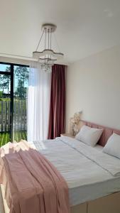 a bedroom with a large bed and a chandelier at Alisa's apartments Ureki in Ureki