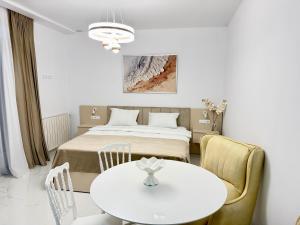 a room with a bed and a table and chairs at Alisa's apartments Ureki in Ureki