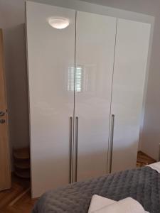 a large white cabinet in a bedroom with a bed at Apartment Stara Novalja 6375c in Novalja