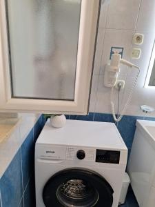 a washing machine in a bathroom with a cabinet at Apartment Stara Novalja 6375c in Novalja