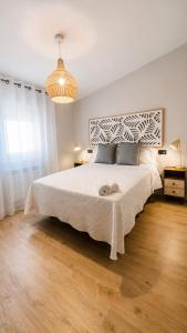 a bedroom with a large bed and a chandelier at Aurah Home in Tudela