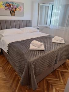 a bed with two towels sitting on top of it at Apartments by the sea Stara Novalja, Pag - 6375 in Novalja