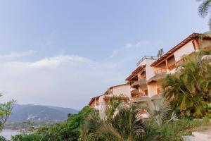 a building on a hill with palm trees at Pacífica Grand Zihuatanejo in Zihuatanejo +2 photos