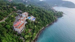 an aerial view of a building on a hill next to the water at Pacífica Grand Zihuatanejo in Zihuatanejo