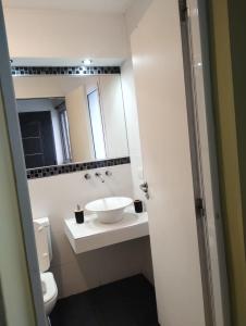 a white bathroom with a sink and a mirror at JAZCA Huayco in San Salvador de Jujuy