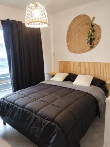 a bedroom with a large black bed and a chandelier at JAZCA Huayco in San Salvador de Jujuy