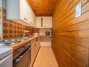 a kitchen with a wooden wall at Das Bergnest Dorfglück in Söll +16 photos