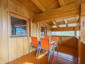 a dining room with orange chairs and a table at Das Bergnest Salvenblick in Söll