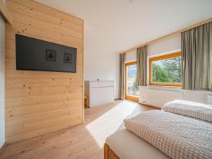 a bedroom with a flat screen tv on a wall at Das Bergnest Heimatblick in Söll
