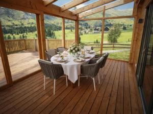 a dining table on a deck with a view at Chalet Gipfelduo in Ebene Reichenau