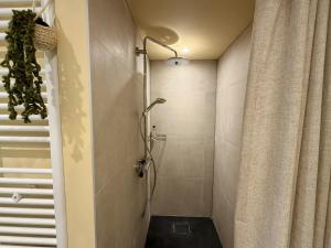 a shower stall in a bathroom with a shower curtain at Villaatje Veluwe in Garderen +27 photos