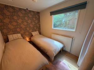 a small room with two beds and a window at Villaatje Veluwe in Garderen