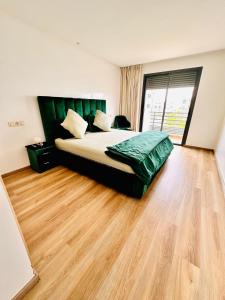 a bedroom with a bed and a wooden floor at Appartement Cozy avec piscine in Sidi Rahal