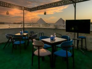 a room with tables and chairs and a television at Happy View INN in Giza