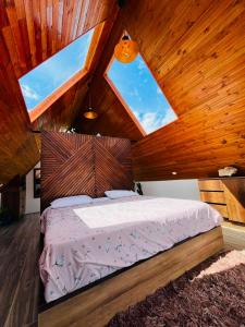 a bedroom with a large bed with two windows at Imperios Glamping in Silvania