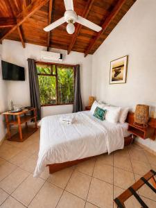 a bedroom with a bed and a ceiling fan at Bahia Esmeralda Boutique Hotel & Villas in Potrero +108 photos