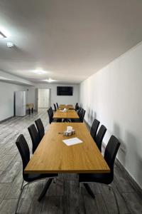 a conference room with a long wooden table and chairs at Pensiunea Ramedal in Calafat