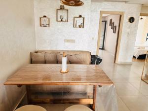 a candle on a wooden table in a living room at Appartement Cozy avec piscine in Sidi Rahal +13 photos