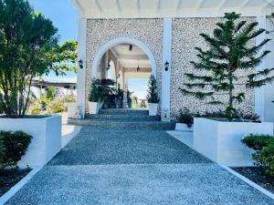 a walkway leading up to a building with plants at Oceano con Vista Mountain Resort in Tagbaobo
