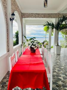 a red table with white chairs and flowers on it at Oceano con Vista Mountain Resort in Tagbaobo