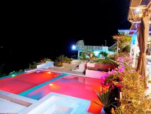 a swimming pool at night with lights on it at Oceano con Vista Mountain Resort in Tagbaobo +4 photos