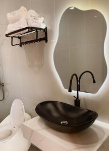 a bathroom with a black sink and a toilet at Black Win Hotel Phu Yen in Mỹ Hòa (1)
