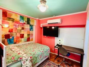 una camera da letto con un letto e una TV di Flat 106 a Tokyo Altre 6 foto