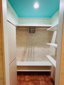 una cabina armadio con armadi bianchi e soffitto blu di Flat 106 a Tokyo