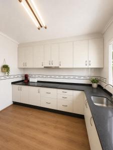 a kitchen with white cabinets and a black counter top at Amazing view bungalow MA2 in Torrevieja