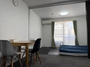 a room with a table and a bed and a mirror at House Nozomi in Kyoto