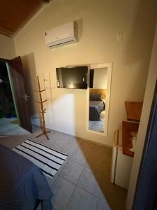 a room with a bedroom with a bed and a mirror at Pousada Caravelas in São Miguel do Gostoso