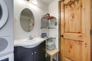 a bathroom with a sink and a mirror and a door at Colorful Cabin w/ Teepee, Fire Pits & Mtn Views! in Marble