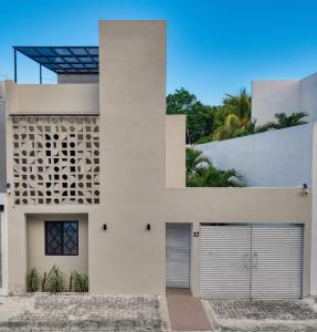 a white house with two garage doors at Casa Gem B&B in Playa del Carmen