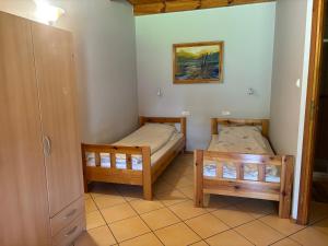 two beds in a small room with a door at k.e.m.p. inn in Krzycko Małe