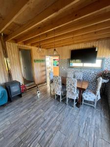 a living room with a table and chairs and a cat at Cabaña en Rafael in Tomé