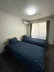 a bedroom with two beds with blue polka dot sheets at House Nozomi in Kyoto
