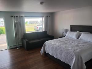 a bedroom with a bed and a couch and a window at Chapel Hill Motel in Moran