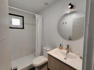 a bathroom with a sink and a toilet and a mirror at Casa acogedora a pasos de la playa in Guaquen