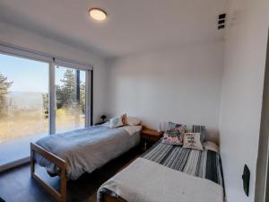 a bedroom with two beds and a large window at Casa acogedora a pasos de la playa in Guaquen