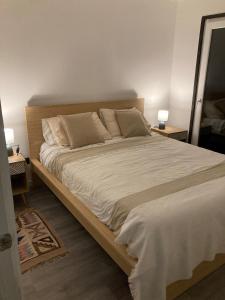a large bed in a bedroom with two lamps at Casa acogedora a pasos de la playa in Guaquen