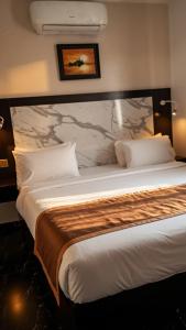 a hotel room with a large bed with a marble headboard at Posh Hotelia in Hausa
