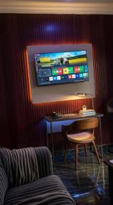 a room with a table with a keyboard and a tv on the wall at Posh Hotelia in Hausa