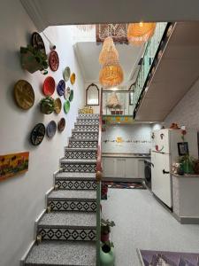 a hallway with stairs and plates on the wall at Riad dar sahrawi in Marrakesh