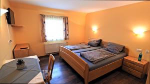 a small room with a bed and a table at Gasthaus Schwarzer Adler in Holzgünz