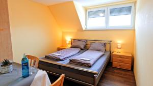 a bedroom with a bed and a window and a table at Gasthaus Schwarzer Adler in Holzgünz